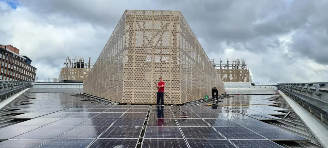 Cleaner washing a large rooftop solar array on a commercial building
