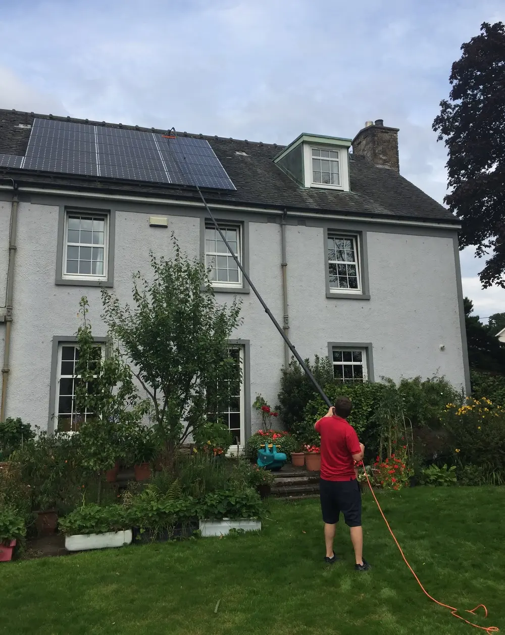 Cleaner reaching roof-mounted solar panels with a water-fed pole